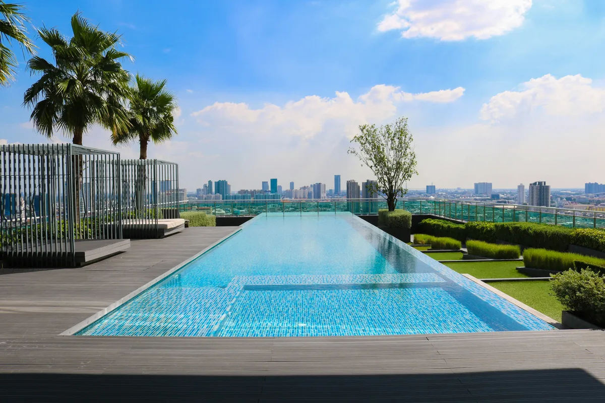 Infinity-edge pool overlooking trees and a city skyline